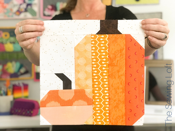 The patchwork construction of the Pretty Pumpkins quilt block makes it perfect for for quilters to play with their scraps. 